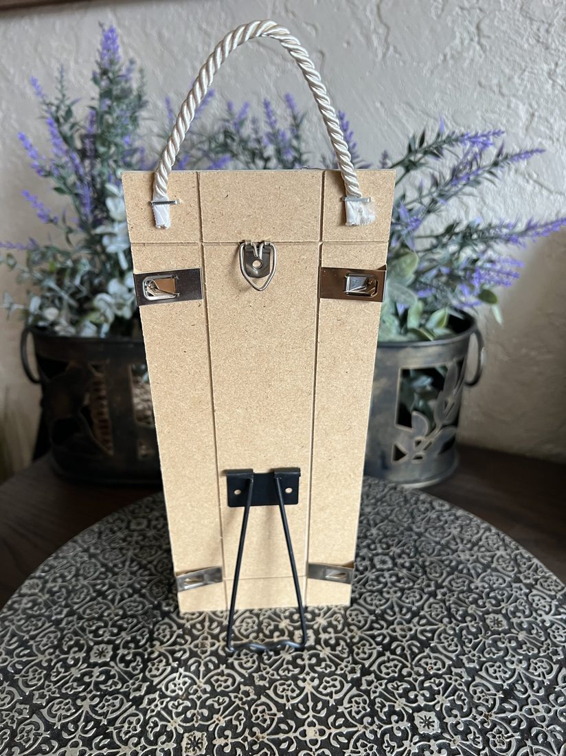 The back of a plaque, standing on its easel, with the rope at the top